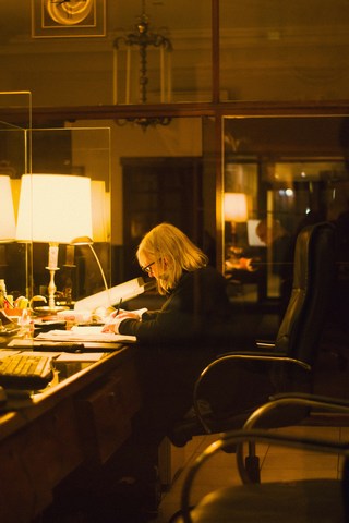 Burned-out woman at desk with dim lighting