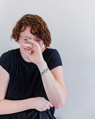 grieving woman holding her face, distraught
