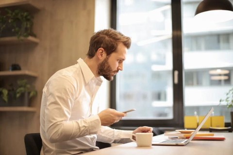 professional man looking stressed staring at laptop in office