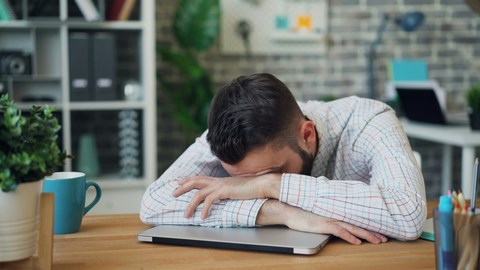 man at work suffering from stress and slumped at desk